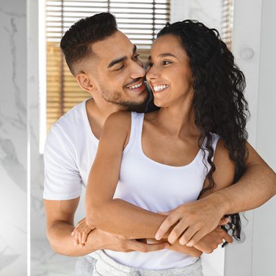 Portrait Of Young Happy Arab Spouses Embracing In Bathroom Interior, Loving Middle Eastern Couple Hugging And Smiling To Each Other, Enjoying Spending Morning Time Together At Home, Closeup